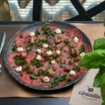 Beef carpaccio, raw porcini mushrooms, fried rocket, and creamy peppered pecorino